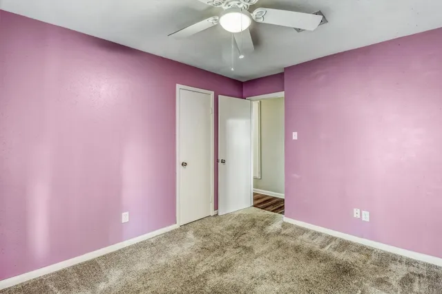 a view of a livingroom with a chandelier fan and a window