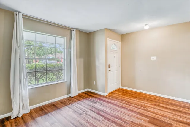 a view of a room with wooden floor and doors
