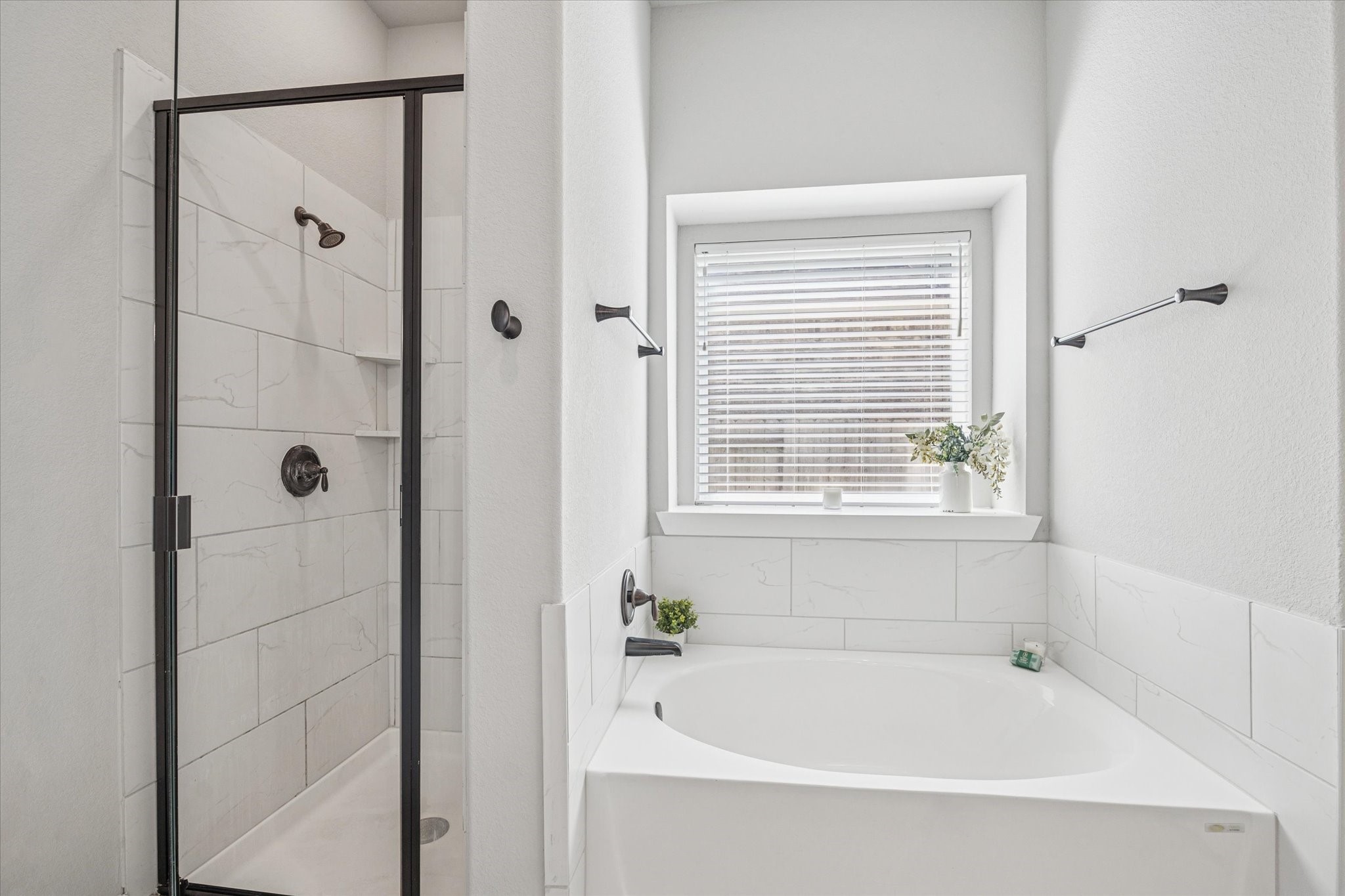 24030 Willow Rose Drive Spring, TX 77389 - Photo 18 of 39 Modern shower with glass doors & a spacious bathtub. A window with blinds provides natural light.