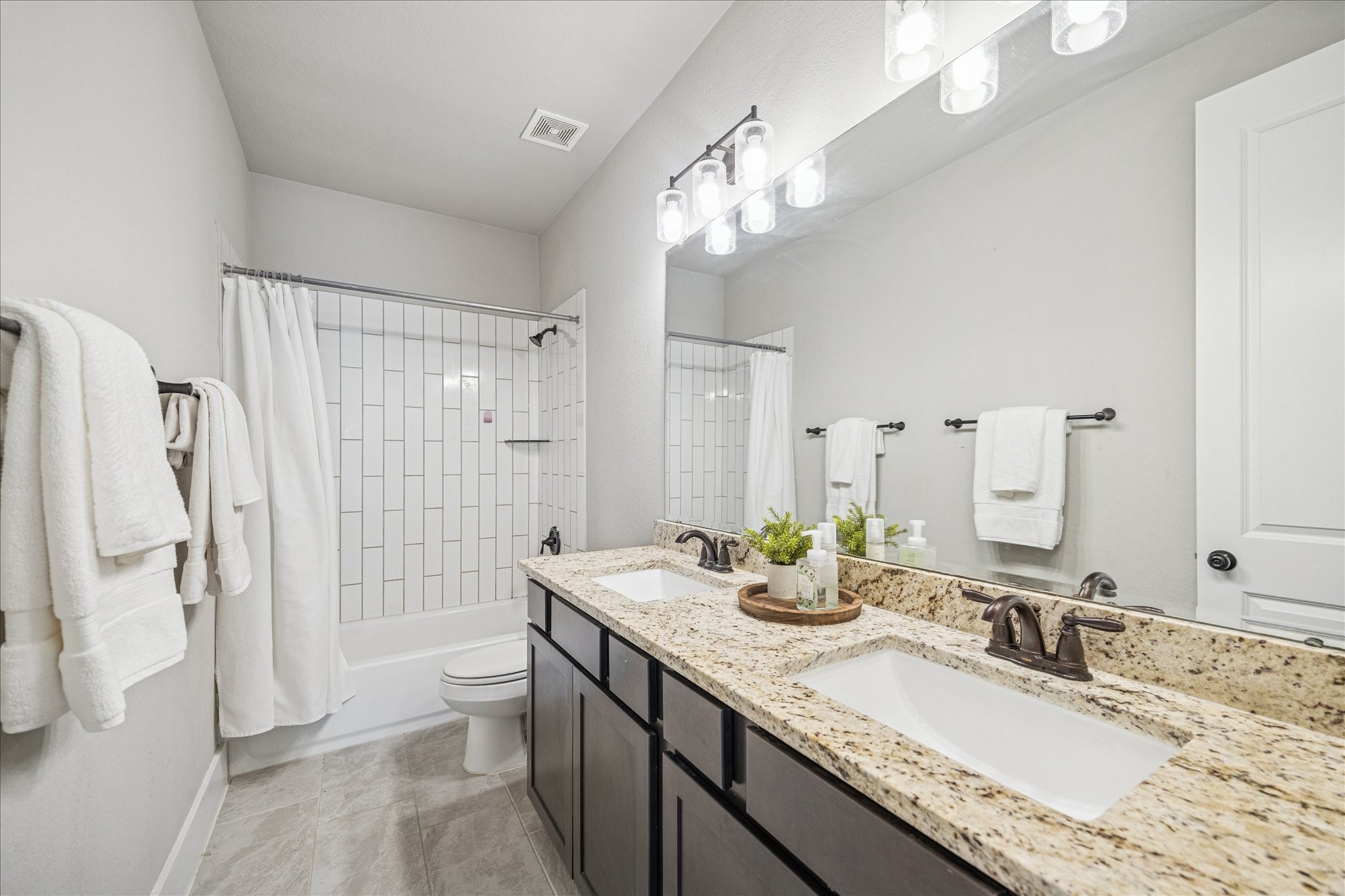 24030 Willow Rose Drive Spring, TX 77389 - Photo 30 of 39 Second upstairs bathroom with modern double vanity, granite countertops, & sleek dark cabinetry.
