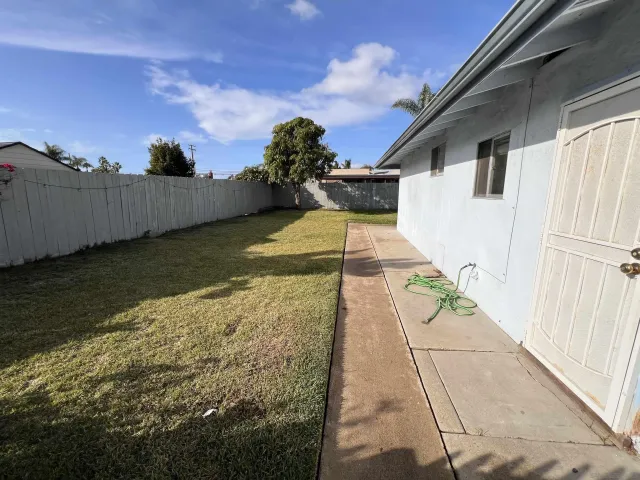 a view of a backyard with wooden fence