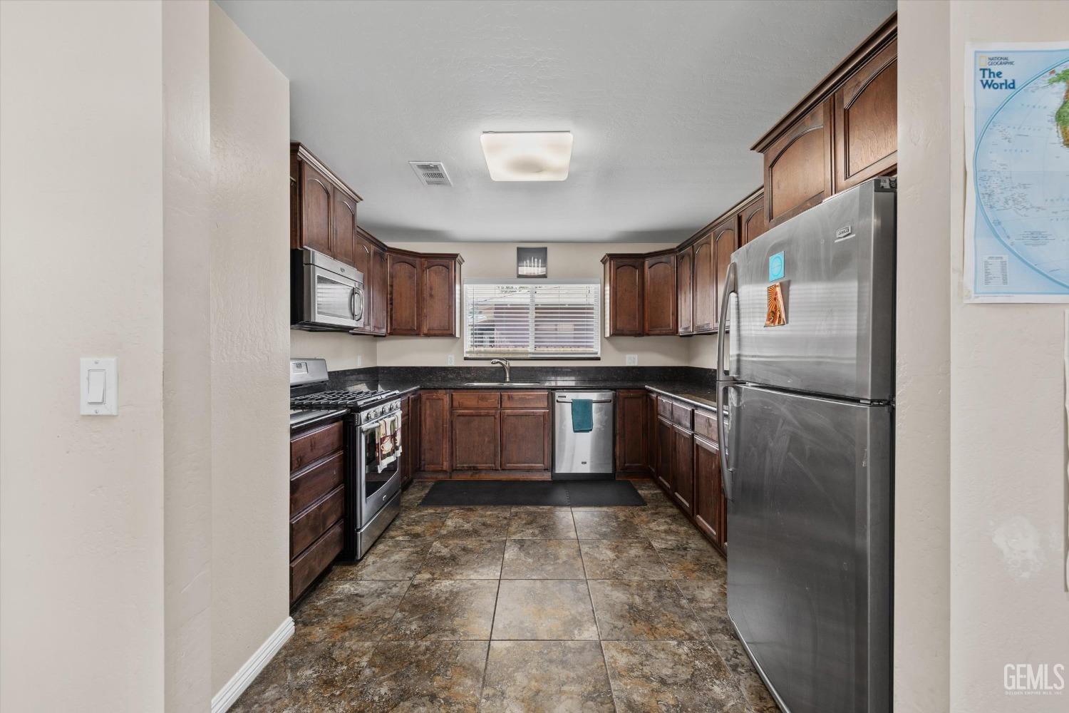 Undisclosed Address Bakersfield, CA 93309 - Photo 13 of 31 a kitchen with stainless steel appliances granite countertop a refrigerator and a stove
