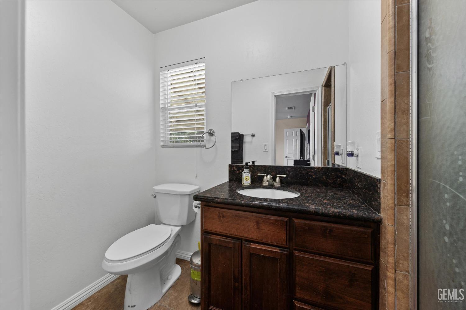 Undisclosed Address Bakersfield, CA 93309 - Photo 21 of 31 a bathroom with a granite countertop sink toilet and mirror
