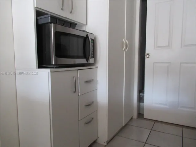 a view of a kitchen with white cabinets and stainless steel appliances