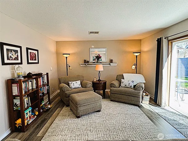 a kitchen with stainless steel appliances granite countertop a stove top oven a refrigerator a sink and dishwasher with wooden floor