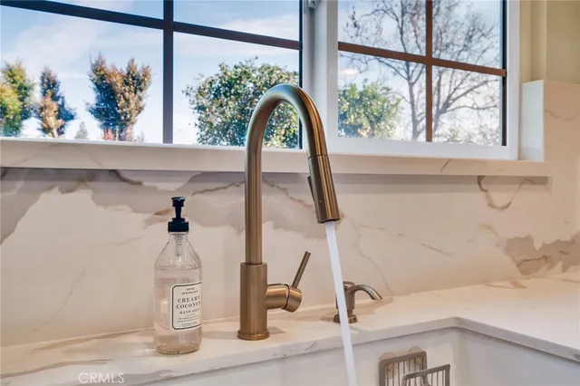 a view of an empty room with wooden floor and a fireplace