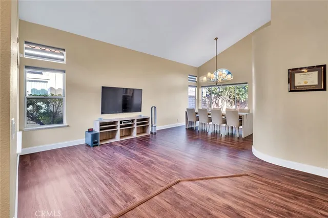 a view of a living room and dining room with wooden floor