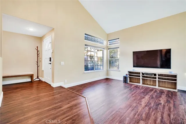 a view of a livingroom with wooden floor and furniture