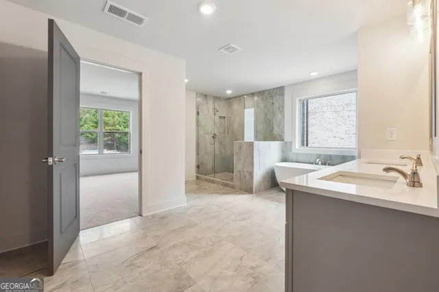 a spacious bathroom with a granite countertop sink a mirror and a shower