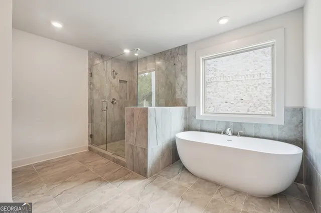 a spacious bathroom with a bathtub and shower