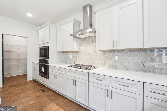 a kitchen with stainless steel appliances granite countertop a sink a stove and a refrigerator