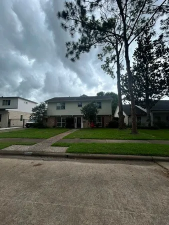 a front view of house with a garden and trees