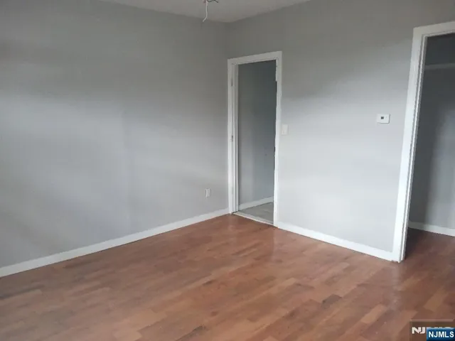 an empty room with wooden floor and closet