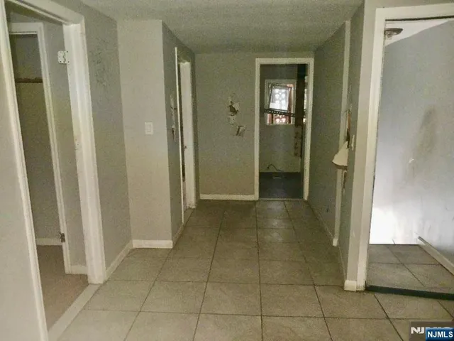 a view of a hallway with closet and bathroom