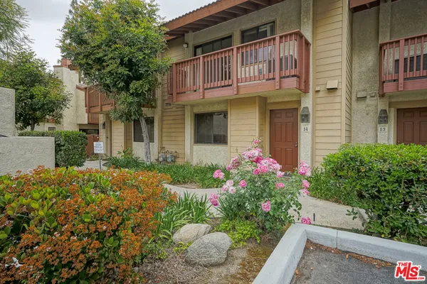 a front view of a house with a yard and a garden