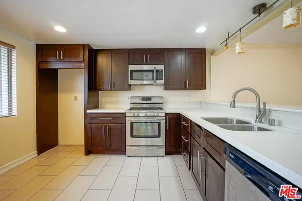 a kitchen with stainless steel appliances granite countertop a sink and a stove top oven