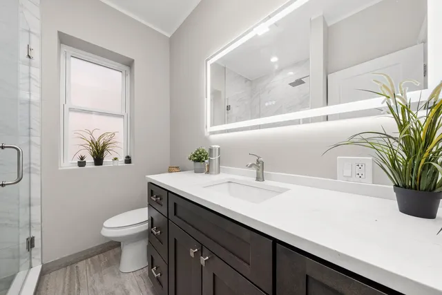 a bathroom with a sink a toilet and a window