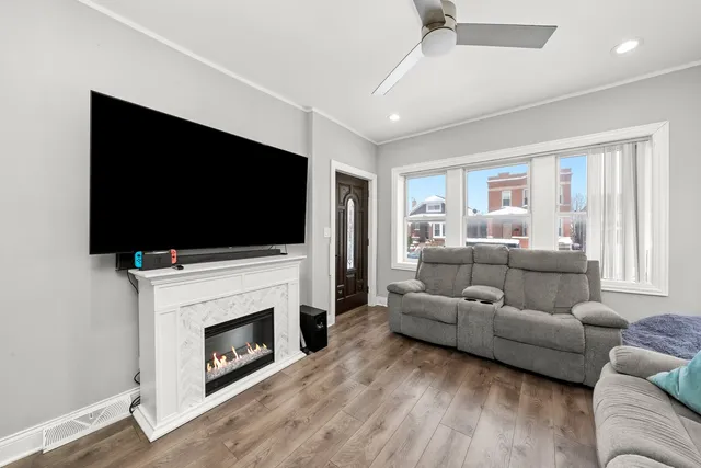 a living room with furniture a flat screen tv a window and a fireplace