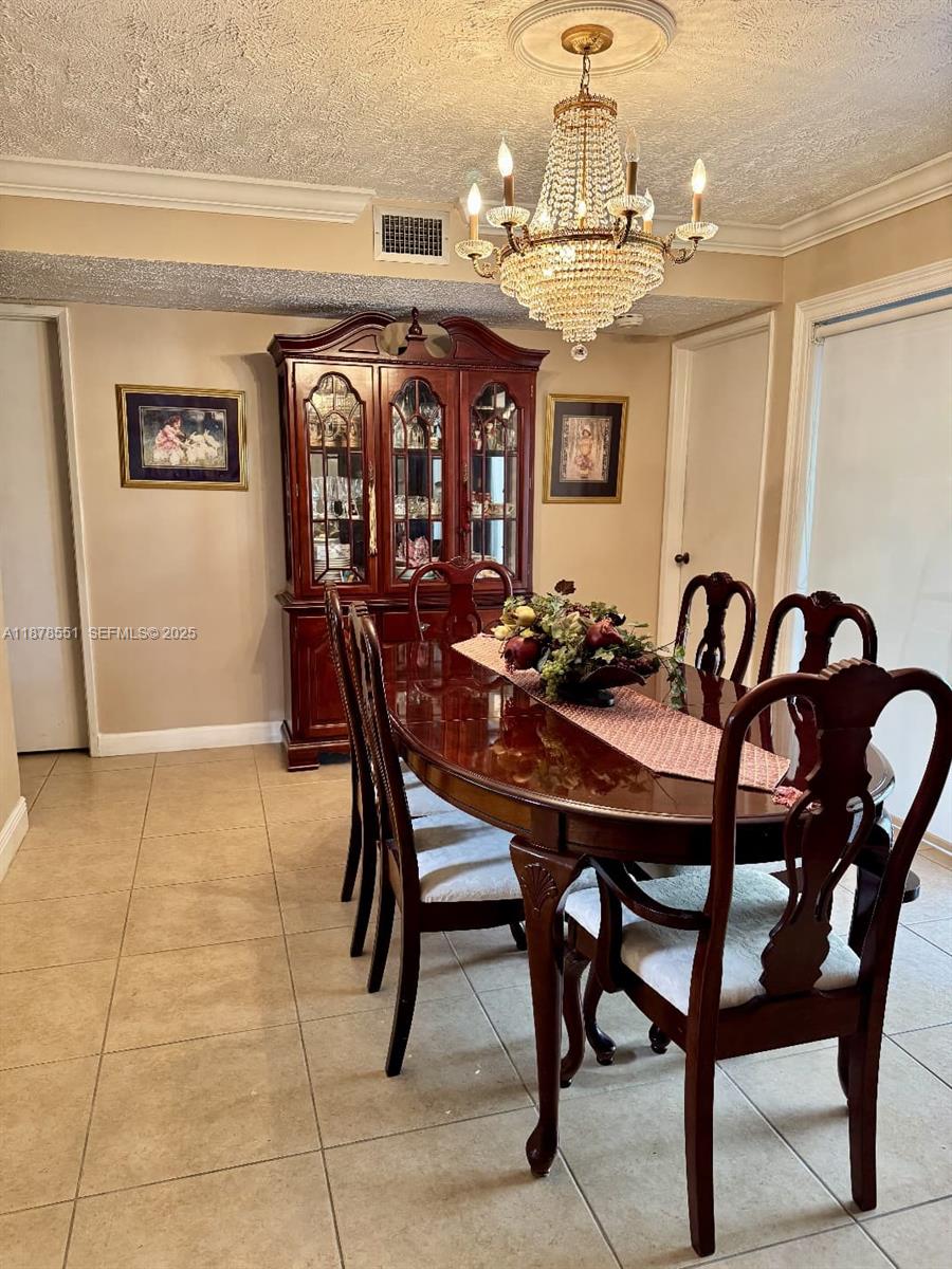 8933 Southwest 123rd Court, Unit 102 Miami, FL 33186 - Photo 13 of 19 a view of a dining room with furniture and chandelier