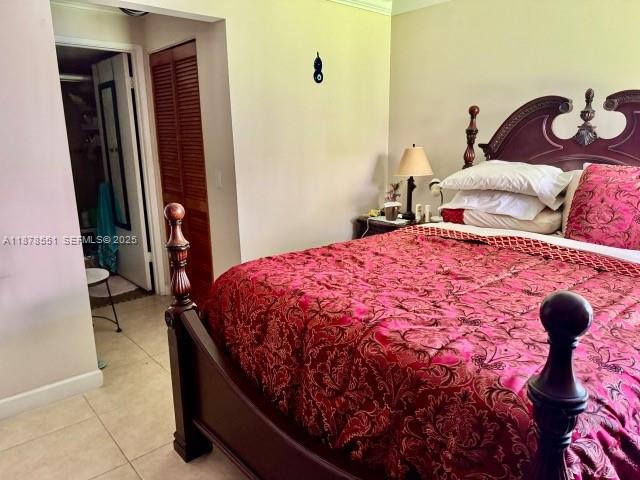 8933 Southwest 123rd Court, Unit 102 Miami, FL 33186 - Photo 17 of 19 a bedroom with a bed and a mirror