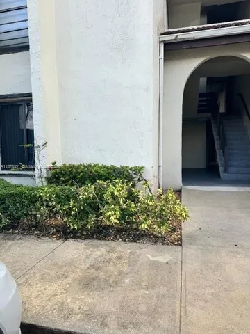 a view of a small house with potted plants