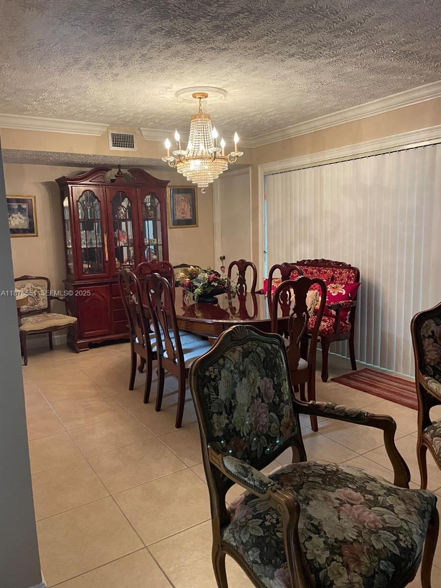 8933 Southwest 123rd Court, Unit 102 Miami, FL 33186 - Photo 10 of 19 a living room with furniture a chandelier and a rug