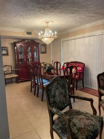 a living room with furniture a chandelier and a rug