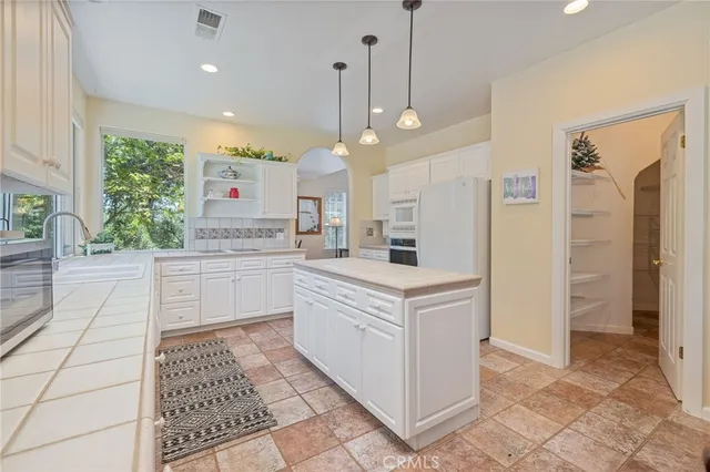 a dining room with wooden floor a chandelier a wooden table and chairs