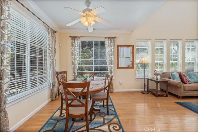 a kitchen that has a lot of white cabinets and stainless steel appliances