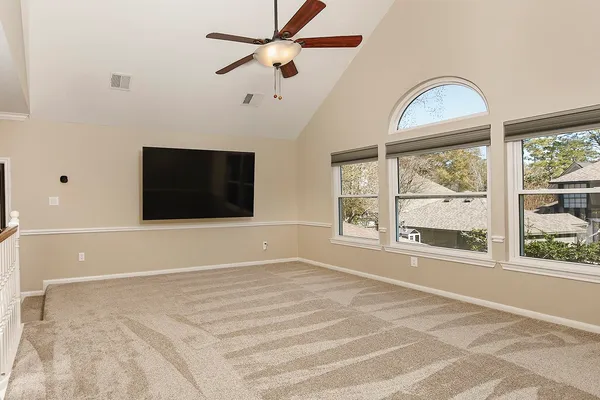 a front view of a house with yard and trees in the background
