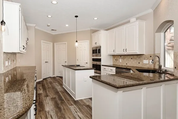 a view of a living room and kitchen floor to ceiling windows with wooden floor