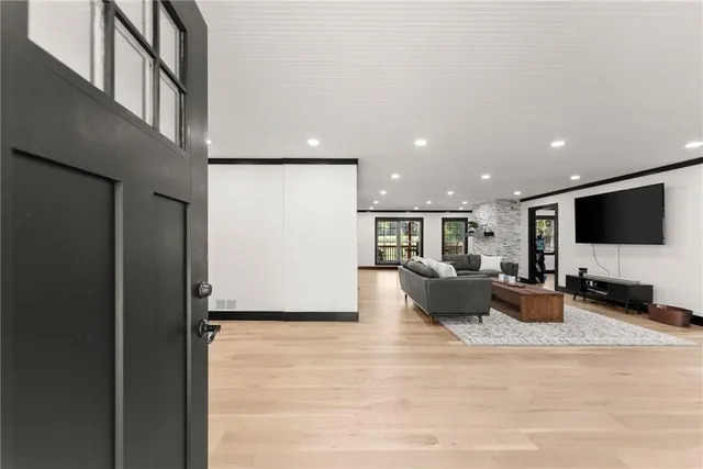 a living room with furniture and a fireplace with kitchen view