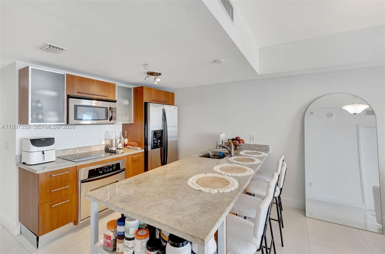 185 Southwest 7th Street, Unit 2303 Miami, FL 33130 - Photo 12 of 40 a kitchen with a table a stove a refrigerator and a dining table