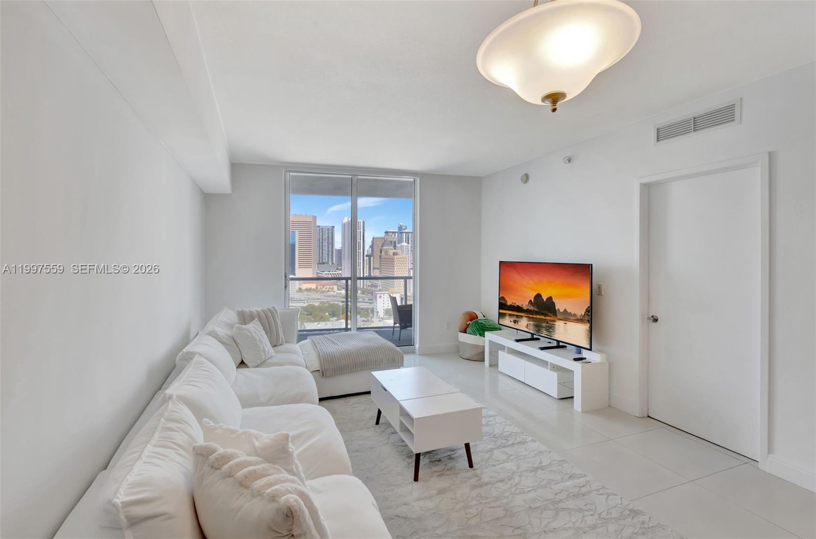 185 Southwest 7th Street, Unit 2303 Miami, FL 33130 - Photo 14 of 40 a living room with furniture and a flat screen tv