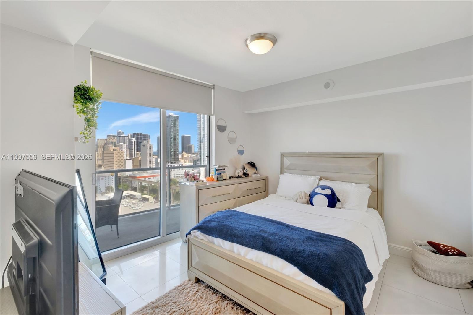 185 Southwest 7th Street, Unit 2303 Miami, FL 33130 - Photo 17 of 40 a bedroom with a large bed and glass door