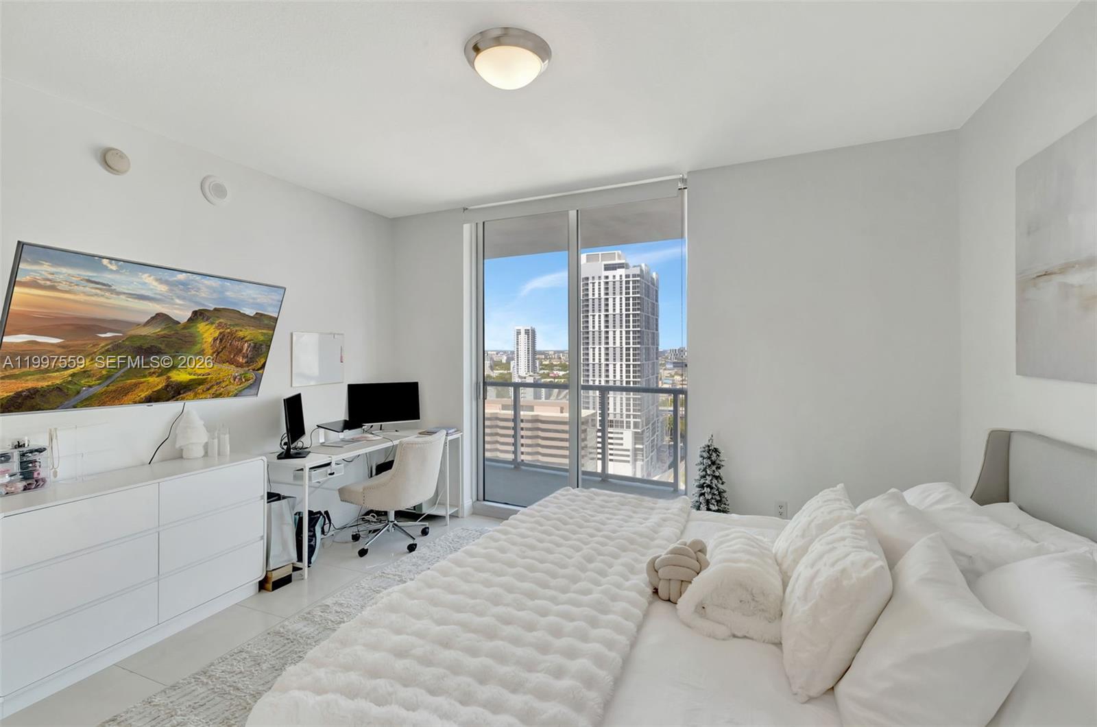 185 Southwest 7th Street, Unit 2303 Miami, FL 33130 - Photo 21 of 40 a bedroom with a large window and a chair