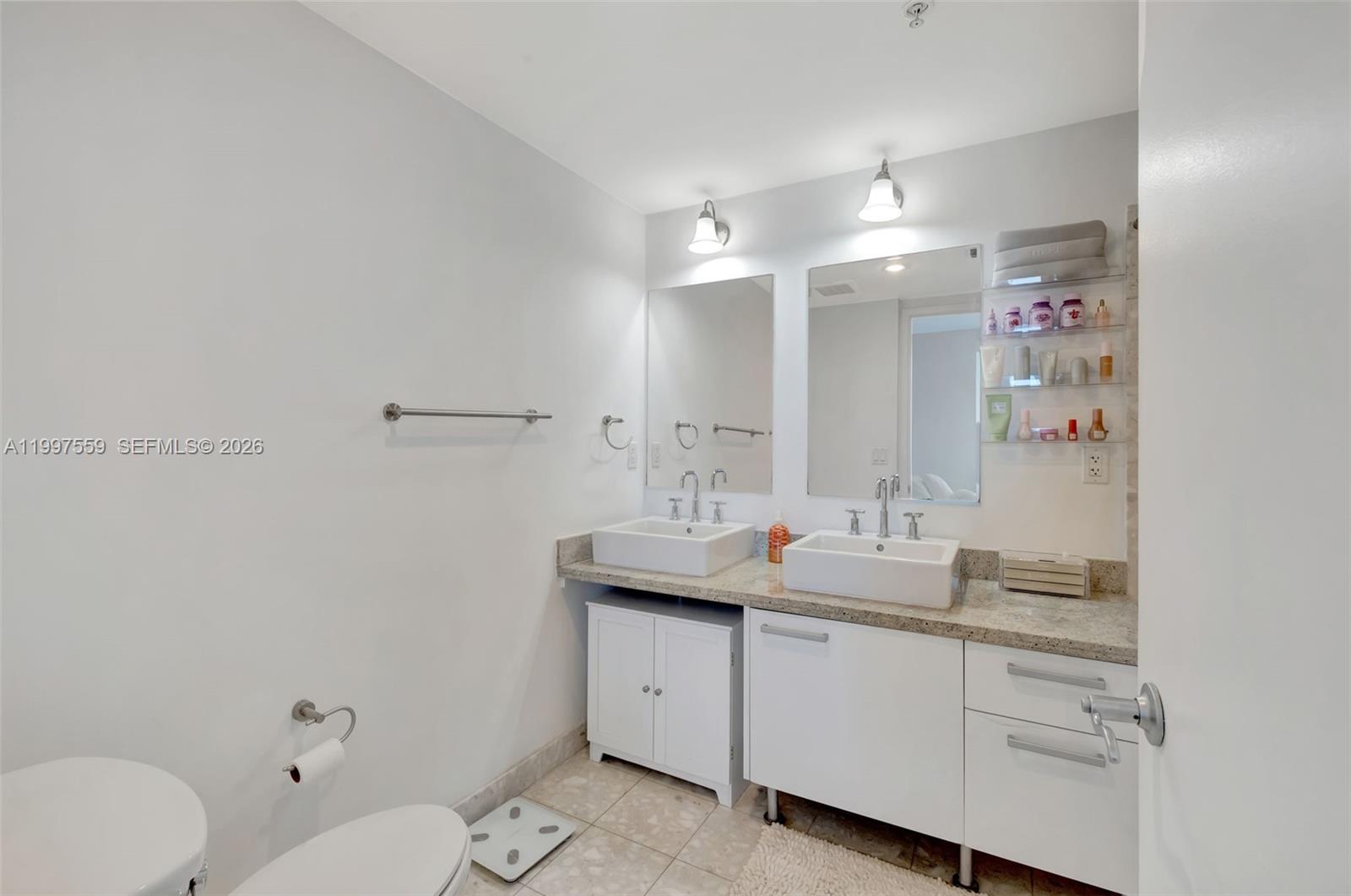 185 Southwest 7th Street, Unit 2303 Miami, FL 33130 - Photo 23 of 40 a bathroom with a granite countertop sink mirror and toilet