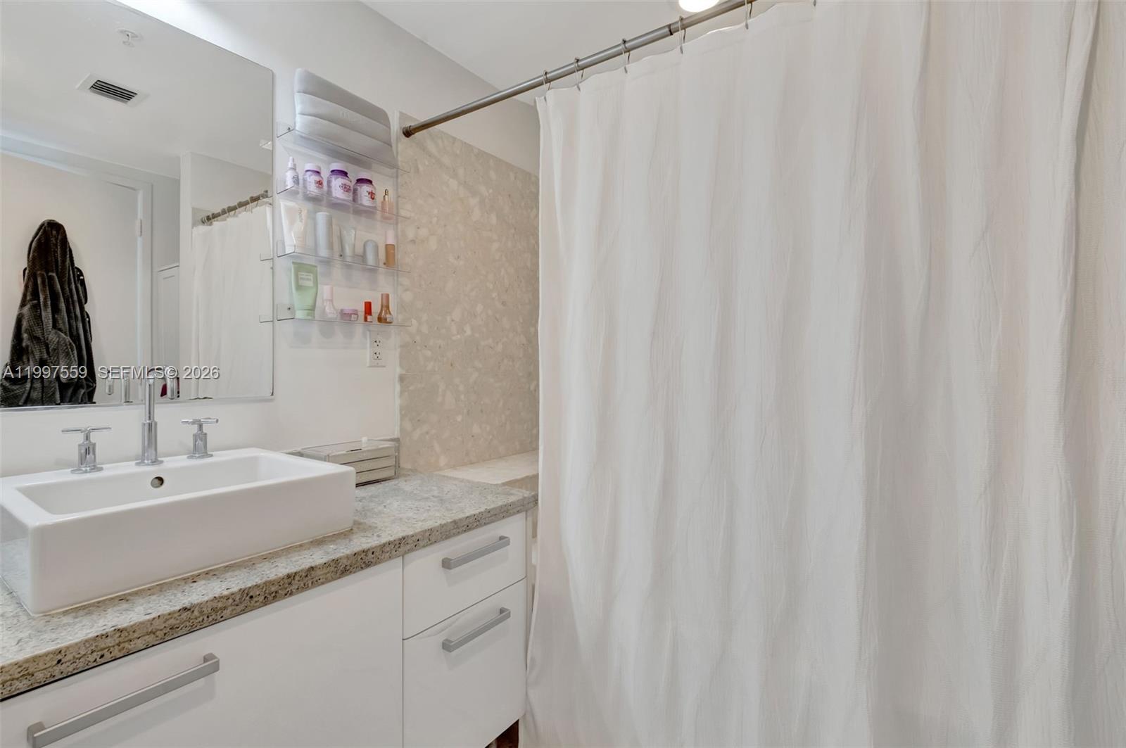 185 Southwest 7th Street, Unit 2303 Miami, FL 33130 - Photo 24 of 40 a bathroom with a sink and a mirror