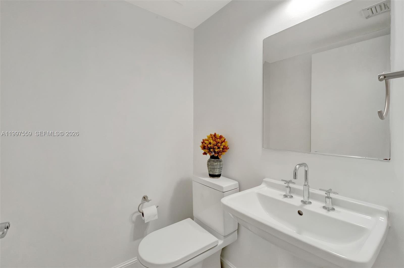 185 Southwest 7th Street, Unit 2303 Miami, FL 33130 - Photo 26 of 40 a bathroom with a sink a toilet and mirror