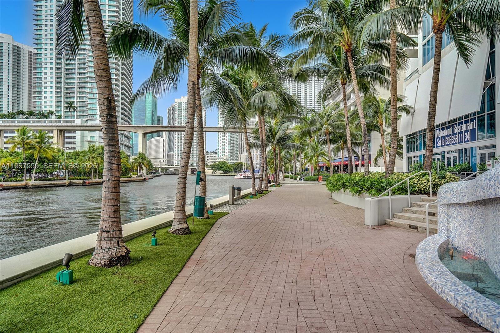 185 Southwest 7th Street, Unit 2303 Miami, FL 33130 - Photo 28 of 40 a view of a patio with table and chairs potted plants and palm trees