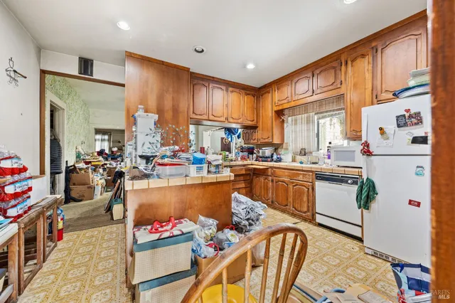 a kitchen with stainless steel appliances granite countertop a refrigerator and a stove top oven