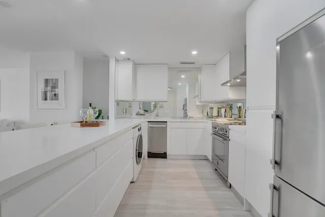 a kitchen with white cabinets and white appliances