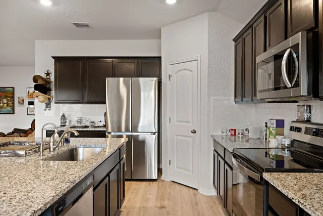 a kitchen with stainless steel appliances granite countertop a sink stove and refrigerator