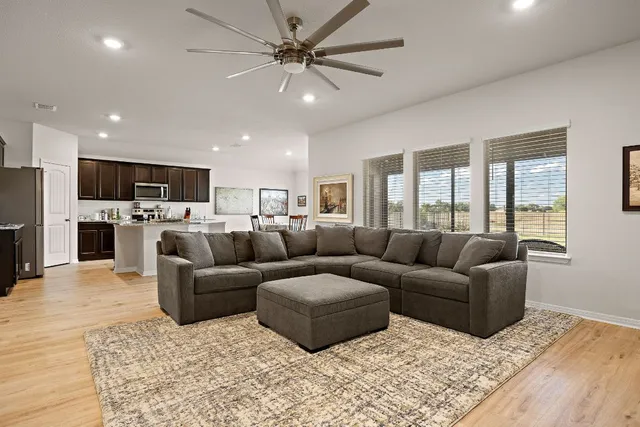 a living room with furniture and a view of kitchen