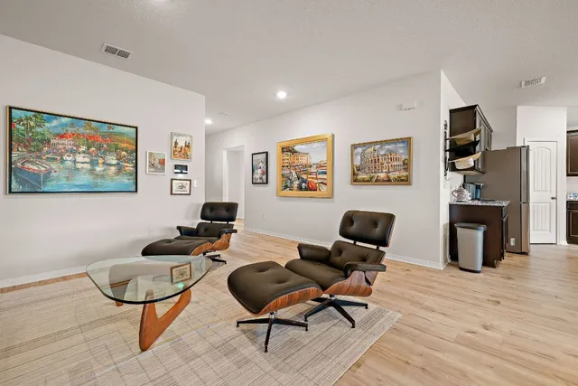 a living room with furniture a rug and a wall painting