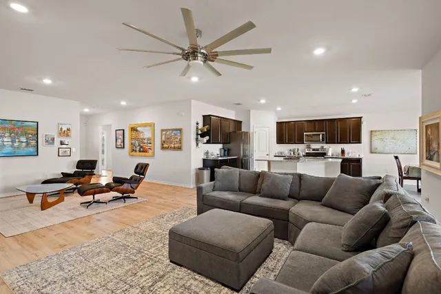 a living room with furniture kitchen view and a window