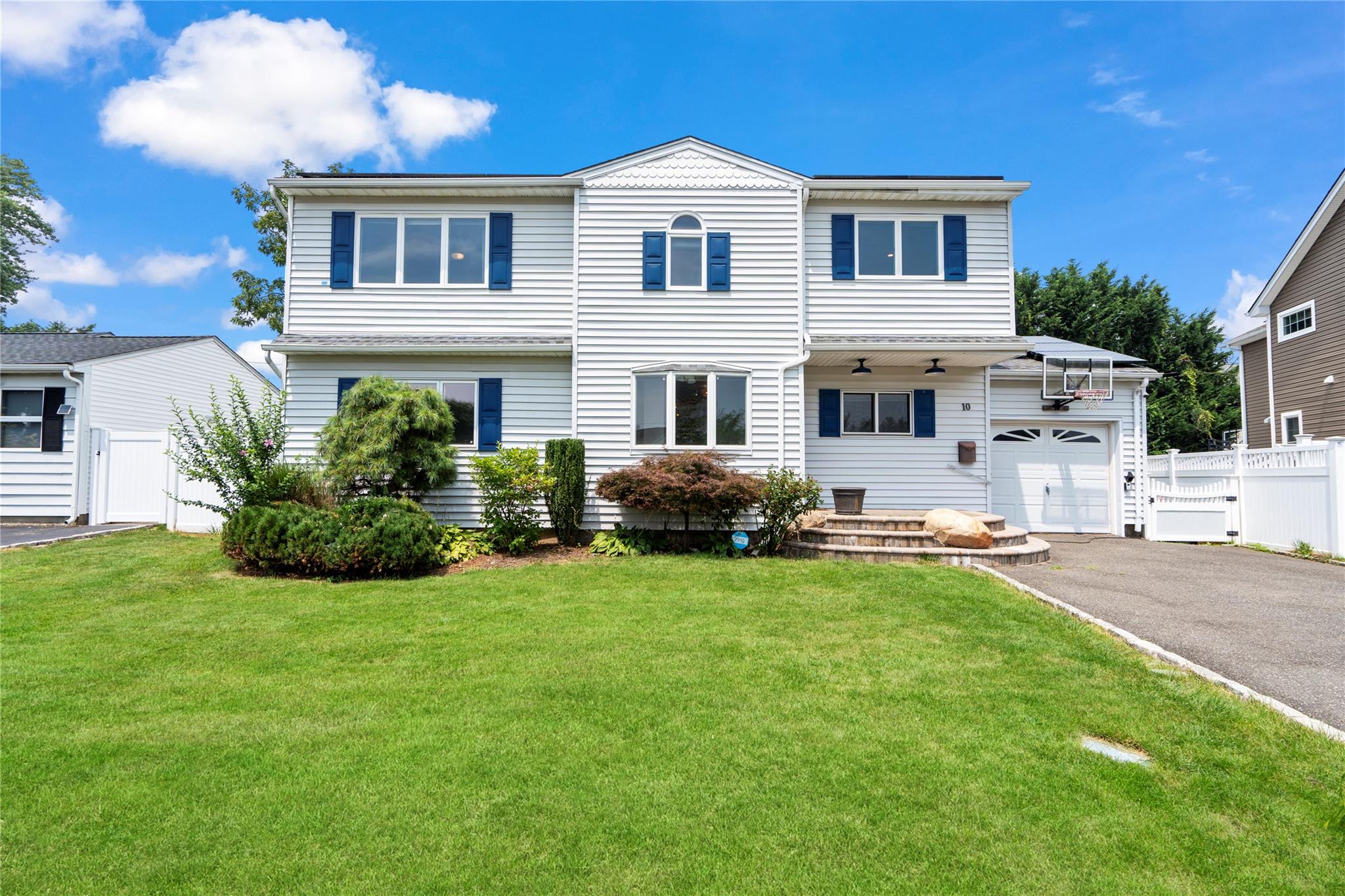 a front view of a house with a garden and plants