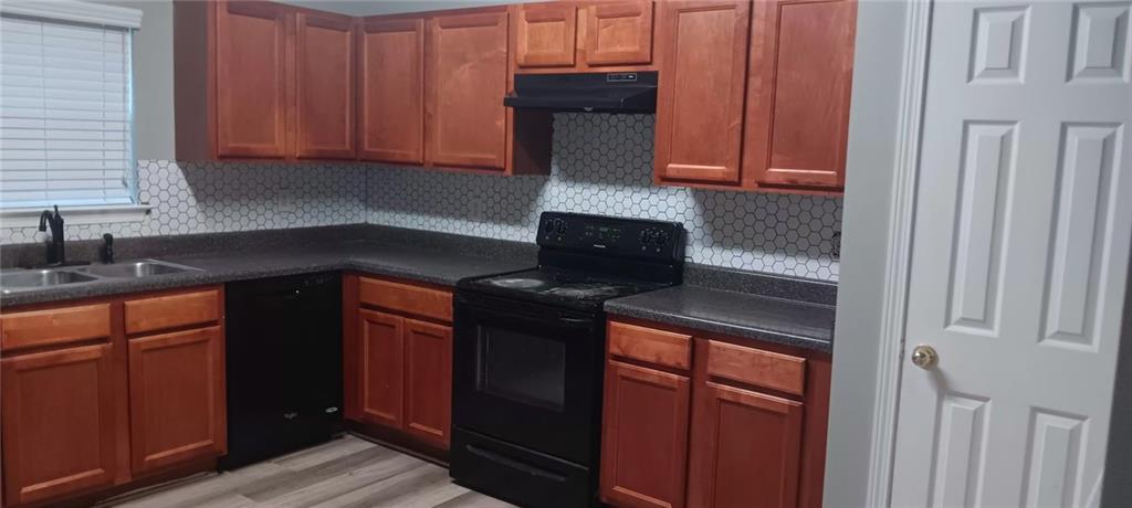 2324 Coach Way Jonesboro, GA 30236 - Photo 11 of 15 a kitchen with granite countertop wooden cabinets and a stove top oven