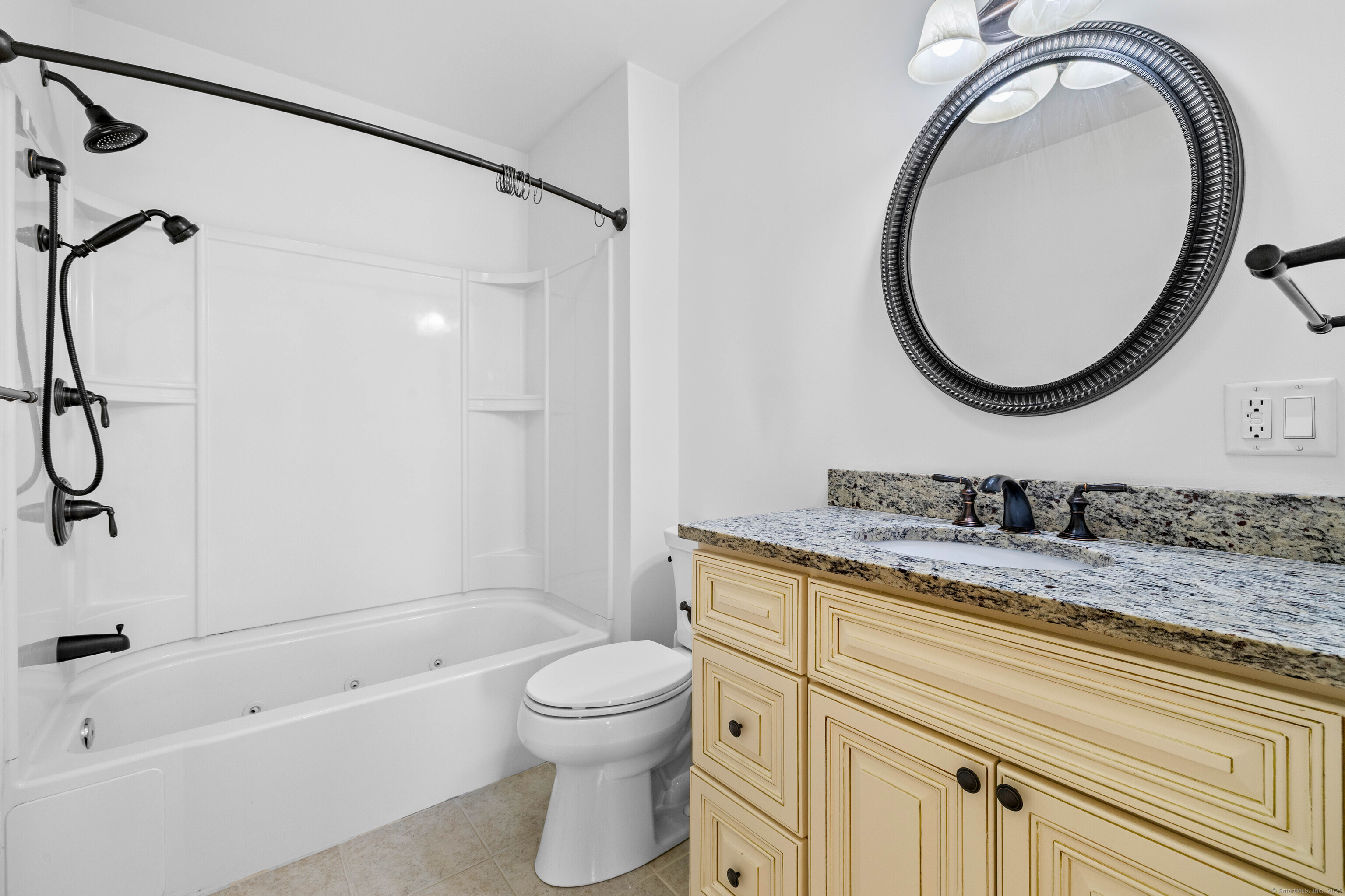 461 Bank Street, Unit 802 New London, CT 06320 - Photo 20 of 35 a bathroom with a granite countertop toilet sink and mirror