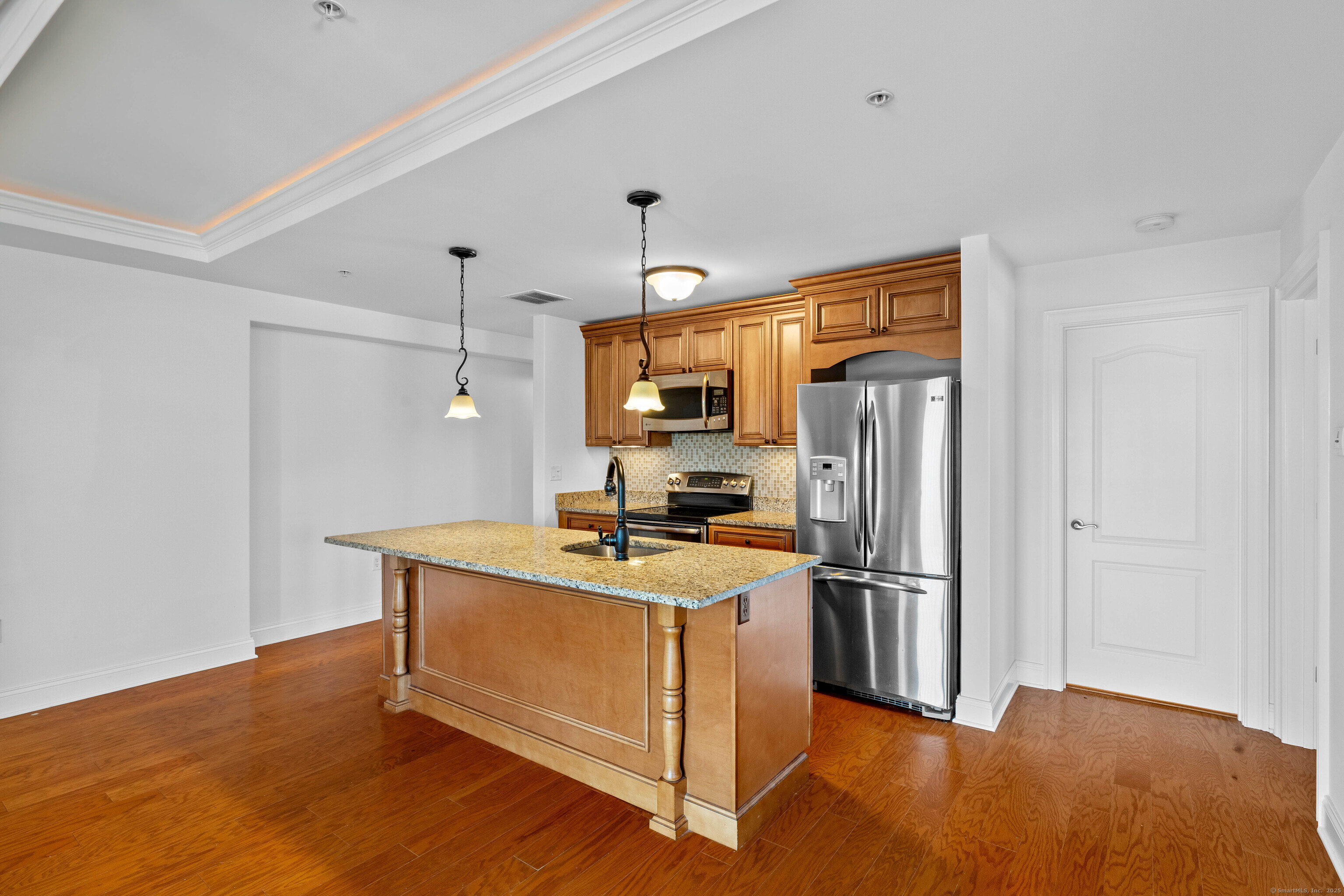 461 Bank Street, Unit 802 New London, CT 06320 - Photo 8 of 35 a kitchen with stainless steel appliances granite countertop a refrigerator a stove and a sink with wooden floor